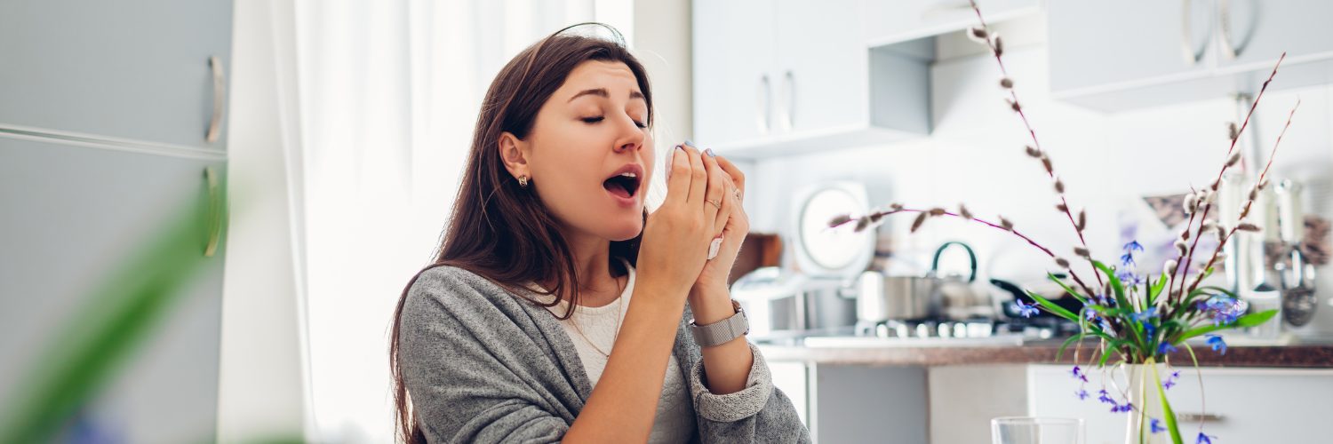 A women sneezing into a tissue.