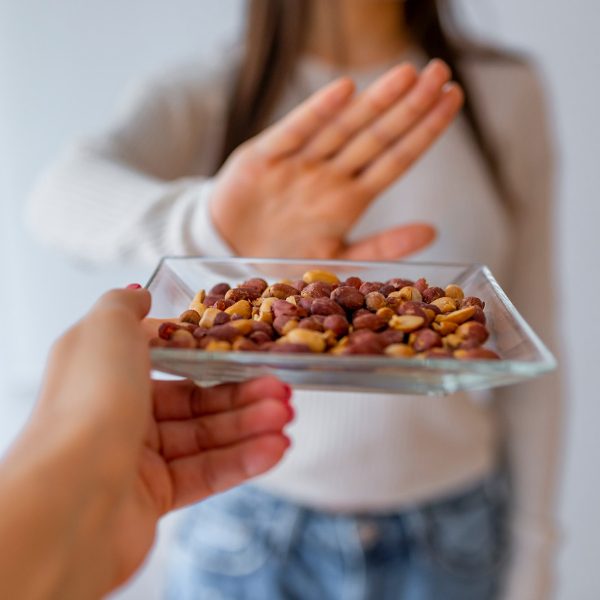 Woman with nut allergy avoiding a plate of nuts